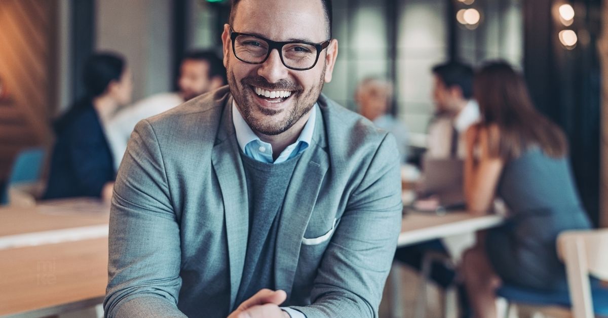 Líder sonriente y cercano que refleja empatía y resiliencia al conectar con su equipo.